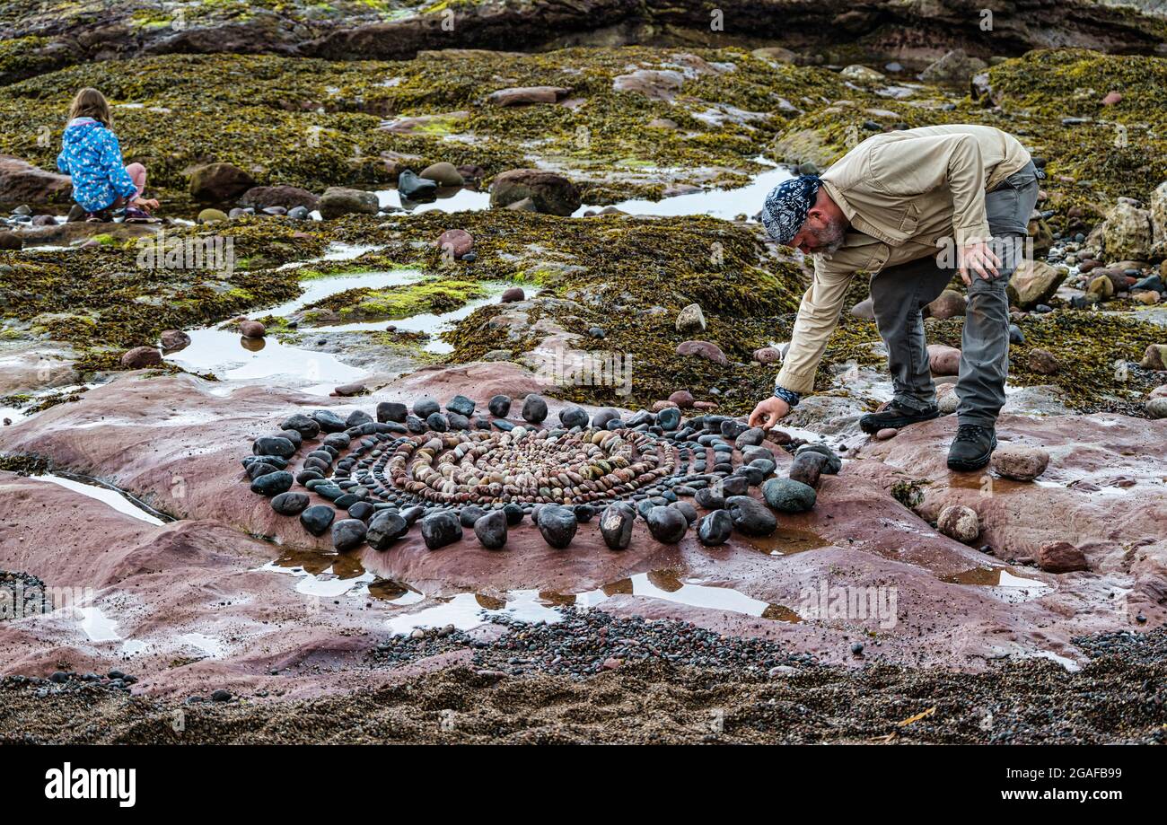 James Brunt, artiste terrestre, crée une sculpture sur roche sur la plage, Dunbar, East Lothian, Écosse, Royaume-Uni Banque D'Images