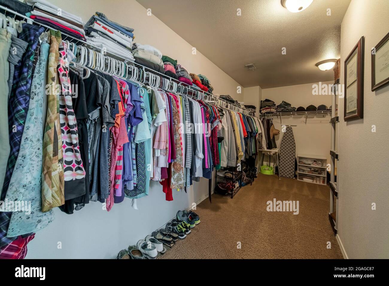 Penderie avec vêtements et chaussures suspendus et empilés Photo Stock -  Alamy