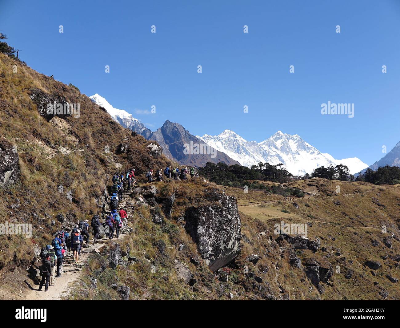 Les randonneurs se rendent sur la piste du bazar Namche avec vue sur le Mont Taboche (partiel) enneigé, Everest et Lhotse en arrière-plan Banque D'Images