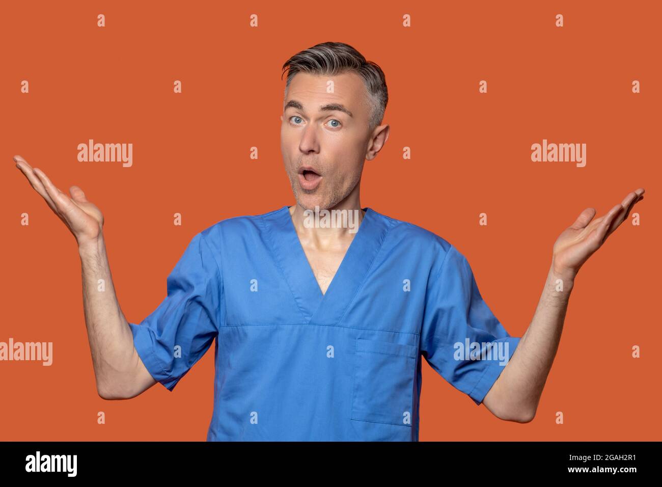 Homme montrant un point d'exclamation et un geste surprise Banque D'Images