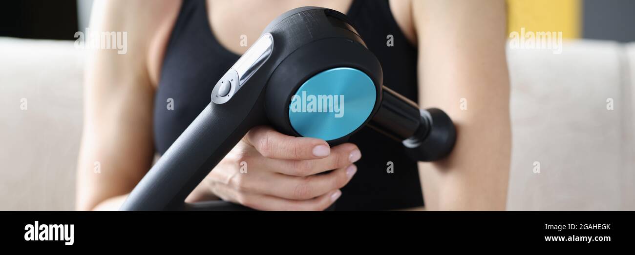 Jeune femme effectuant un massage relaxant pour les mains en vibration masseur Banque D'Images