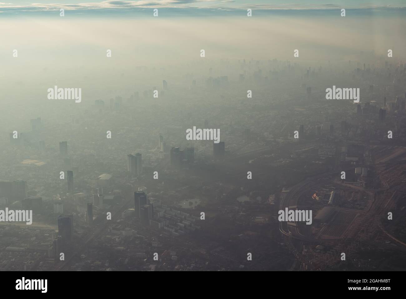 La vue plongeante de la ville de Bangkok, prise à partir d'un avion qui vole le matin avec une couleur de lever du soleil réchauffée et un peu d'ombre des nuages photo peut avoir n Banque D'Images