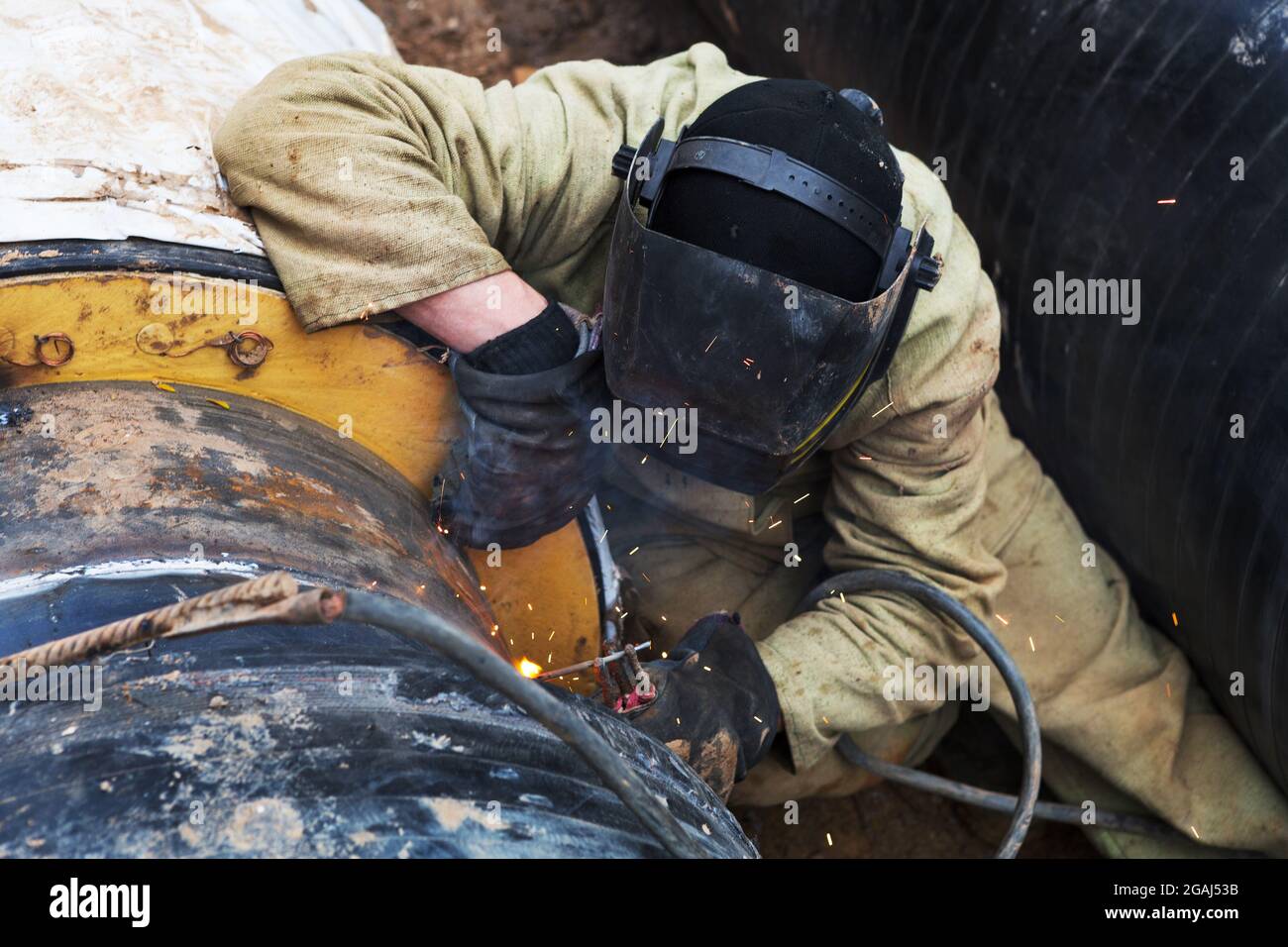 Réparation du conduit de chauffage. Les ouvriers, soudeurs réalisés par  soudage électrique et soudage au gaz sur de grands tuyaux en fer à une  profondeur de tranchée excavée Photo Stock - Alamy