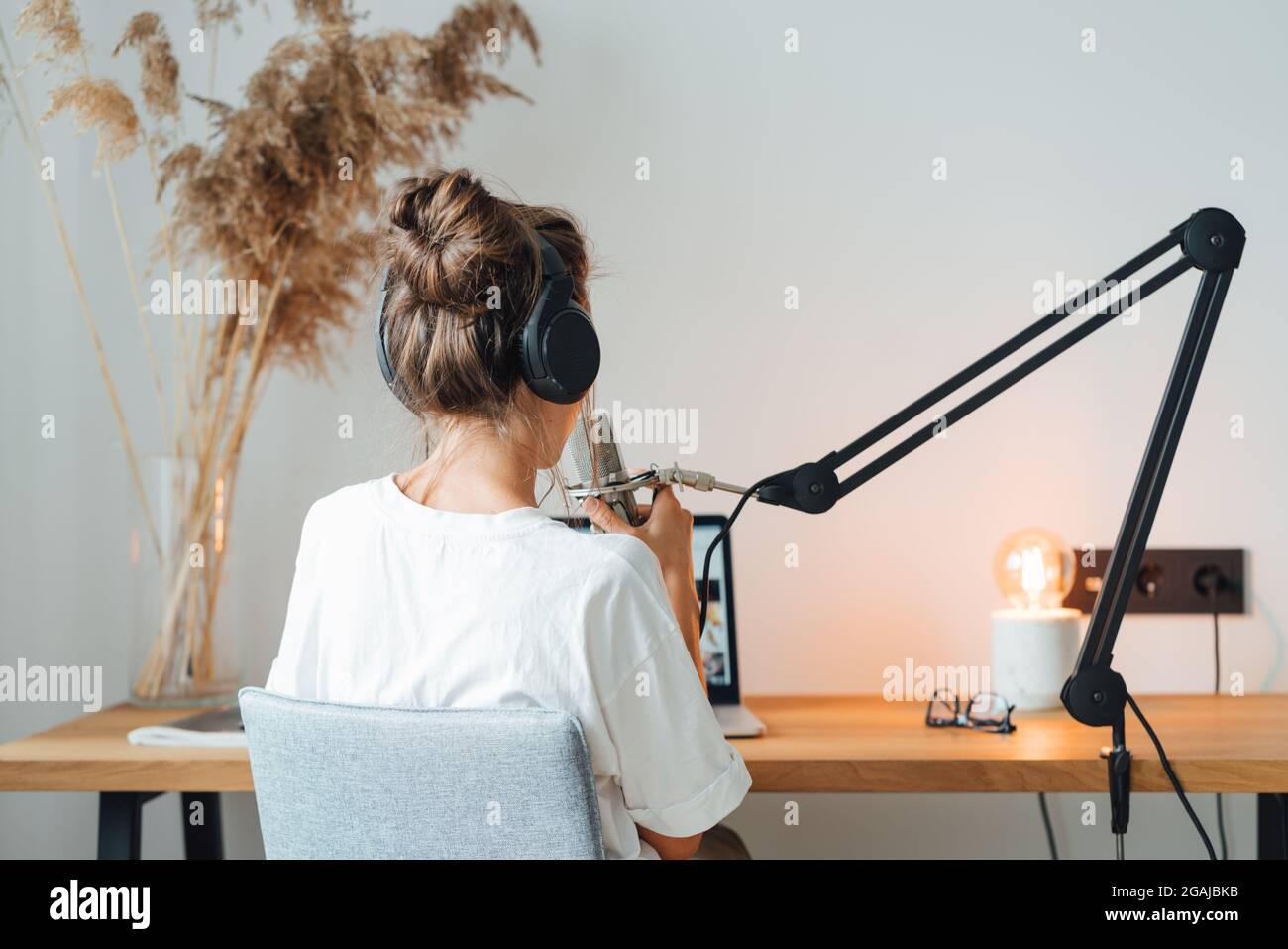 Vue arrière sur femme assis sur table et d'enregistrer le podcast dans son  petit studio de radio confortable. Une femme diffuse sa voix dans le  microphone Photo Stock - Alamy