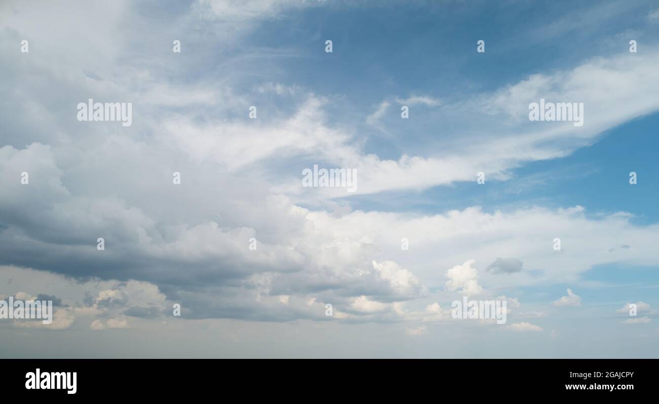 Les nuages gris viennent sur fond bleu ciel Banque D'Images