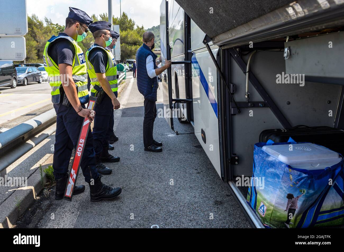 Des agents de police et des douanes vérifient un bus en provenance d'Italie à la frontière avec la France. Le prochain renforcement des mesures de lutte contre l'épidémie de coronavirus en France et l'installation de la passe sanitaire amène le gouvernement à renforcer les contrôles aux frontières. En plus des contrôles habituels, les agents des douanes et la police aérienne et frontalière vérifient la validité de la carte sanitaire et des tests PCR que les voyageurs présentent à leur arrivée. (Photo de Laurent Coust / SOPA Images / Sipa USA) Banque D'Images