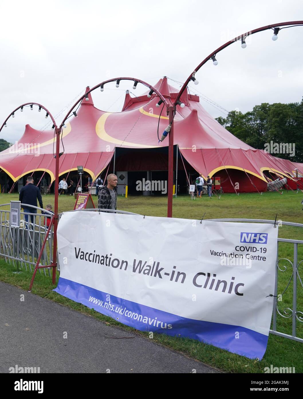 Les gens qui marchent devant la signalisation pour la clinique de vaccination pop-up Covid-19 de Circus Extreme à Halifax. Date de la photo: Samedi 31 juillet 2021. Banque D'Images