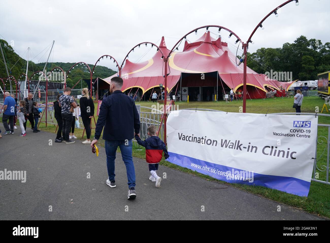 Les gens qui marchent devant la signalisation pour la clinique de vaccination pop-up Covid-19 de Circus Extreme à Halifax. Date de la photo: Samedi 31 juillet 2021. Banque D'Images