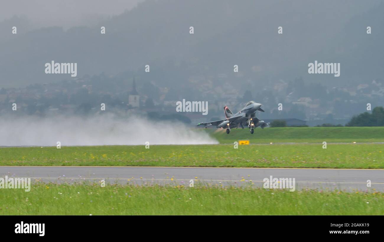 Zeltweg, Autriche 6 SEPTEMBRE 2019 un avion de chasse militaire supersonique prend le dessus en levant un énorme nuage d'eau sur la piste lors de fortes pluies. Eurofighter Typhon de l'armée de l'air autrichienne Banque D'Images