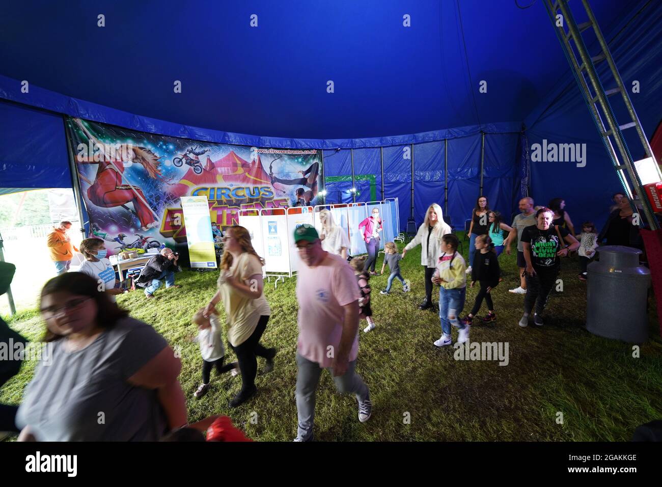 Les gens qui fréquentent Circus Extreme à Halifax, marchent devant une clinique pop-up de vaccination Covid-19 établie dans le chapiteau du cirque. Date de la photo: Samedi 31 juillet 2021. Banque D'Images