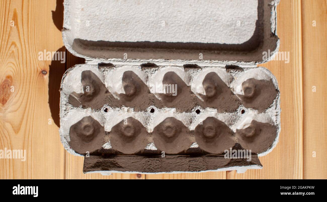 Carton gris à œufs sans œufs sur fond blanc. Boîte en carton à œufs en papier recyclé avec motif abstrait répété Banque D'Images