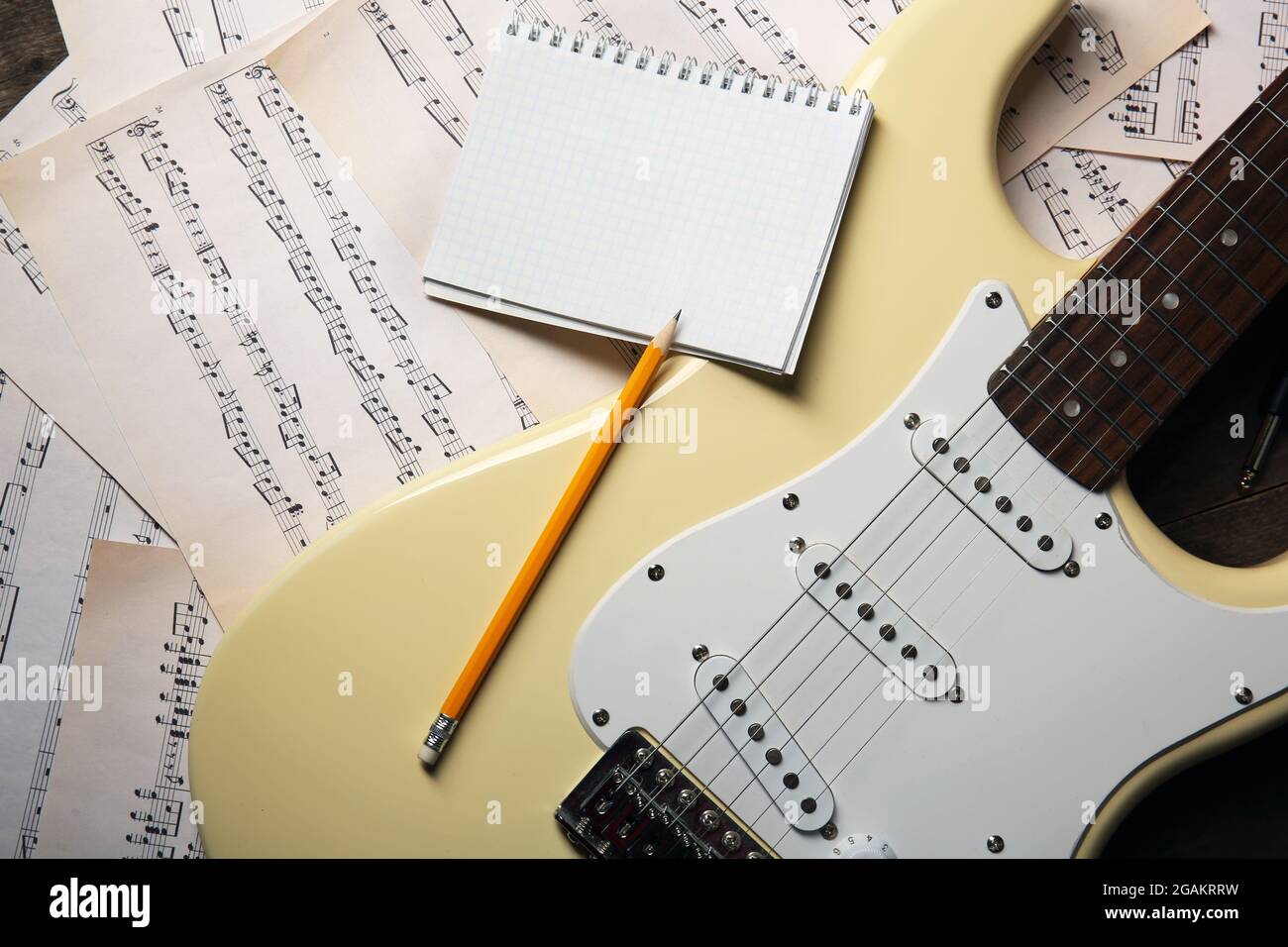 Guitare électrique avec carnet et crayon sur fond de notes musicales Photo  Stock - Alamy
