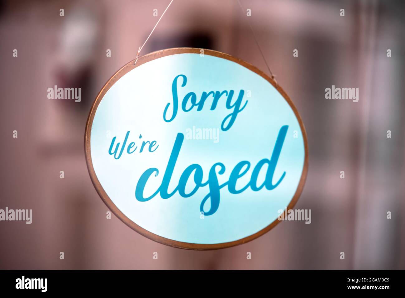 Panneau « nous sommes fermés » derrière le verre réfléchissant au crépuscule Banque D'Images