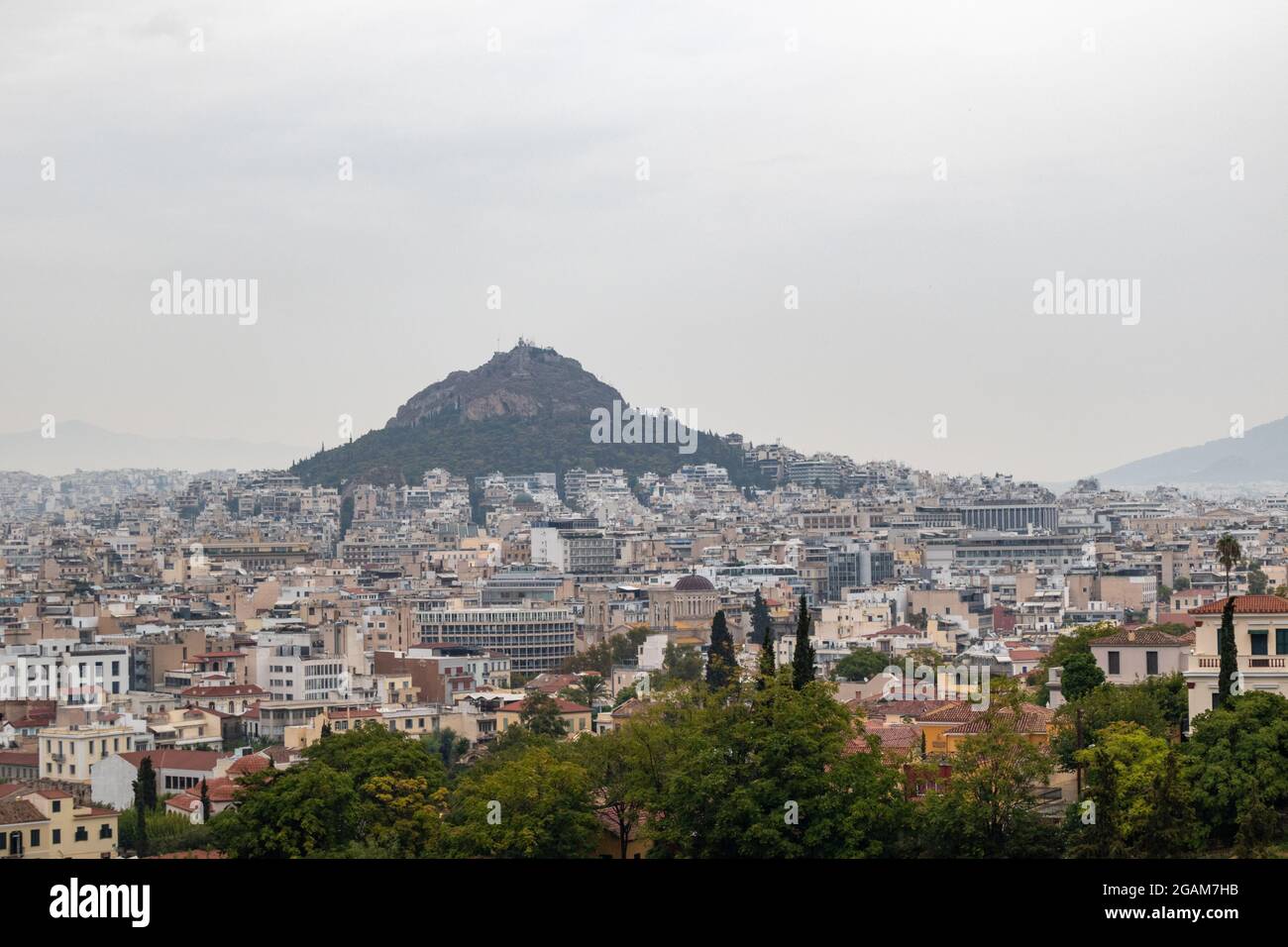 Vue sur le mont Lycabette et le vieux centre-ville d'Athènes avec des bâtiments à l'architecture en journée de brouillard gris d'Areopagus - colline près de l'Acropole Banque D'Images