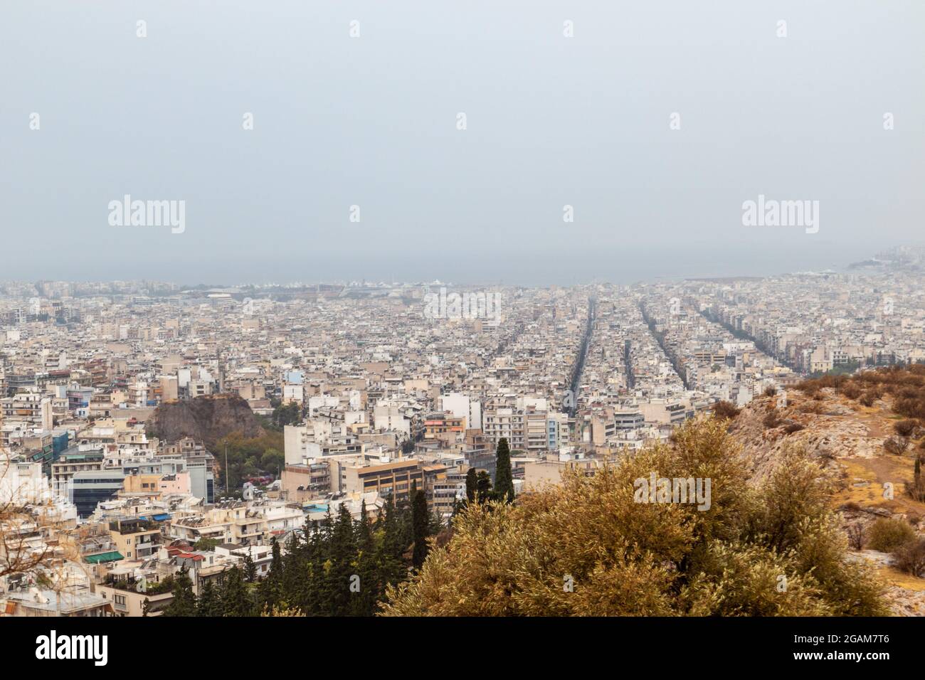 Les rues du centre-ville d'Athènes sont dotées de bâtiments blancs à l'architecture par temps brumeux. Vue sur le toit depuis la colline de Filopappou, près de l'Acropole, Grèce Banque D'Images