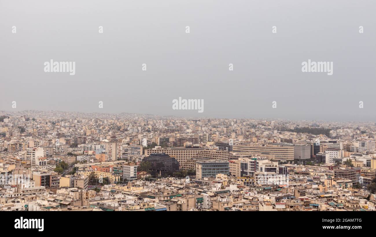 Centre-ville moderne d'Athènes rues surpeuplées avec des bâtiments blancs à l'architecture par temps brumeux. Vue sur le toit depuis la colline de Filopappou près de l'Acropole, Banque D'Images