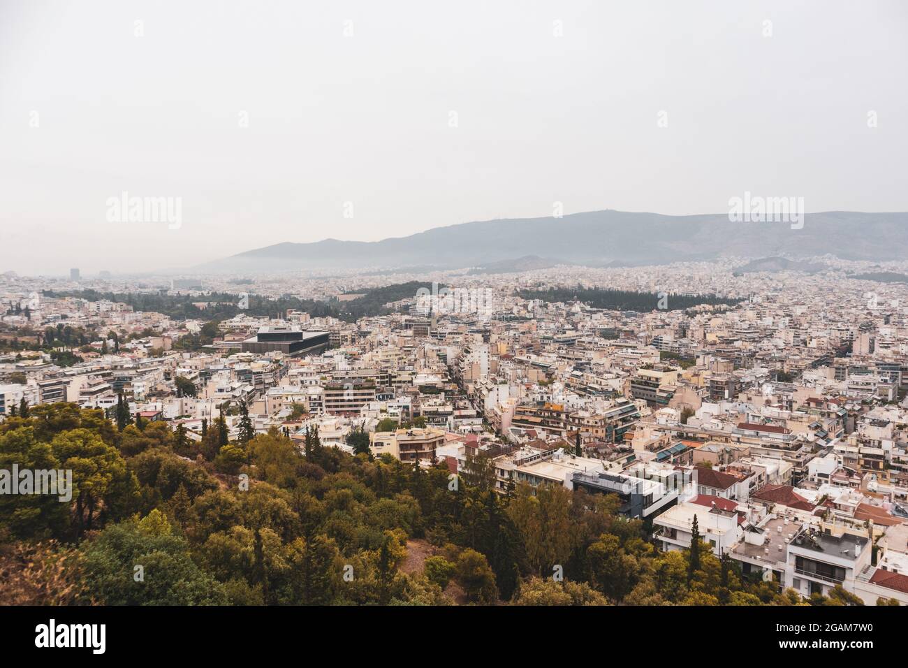 Les rues du centre-ville d'Athènes sont dotées de bâtiments blancs dans des parcs verdoyants par temps de brouillard gris. Vue sur le toit depuis le parc de la colline de Filopappou, près de l'Acropole, en Grèce Banque D'Images