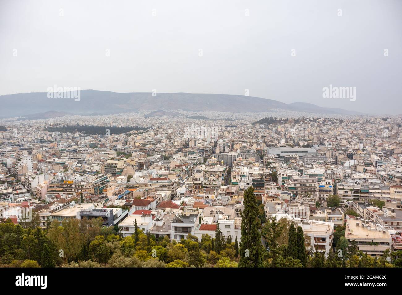 Rues du centre-ville d'Athènes à l'architecture blanche, silhouette de montagne et verdure par temps de brouillard gris. Vue sur le toit depuis le parc de Filopappou Hill près de l'AC Banque D'Images