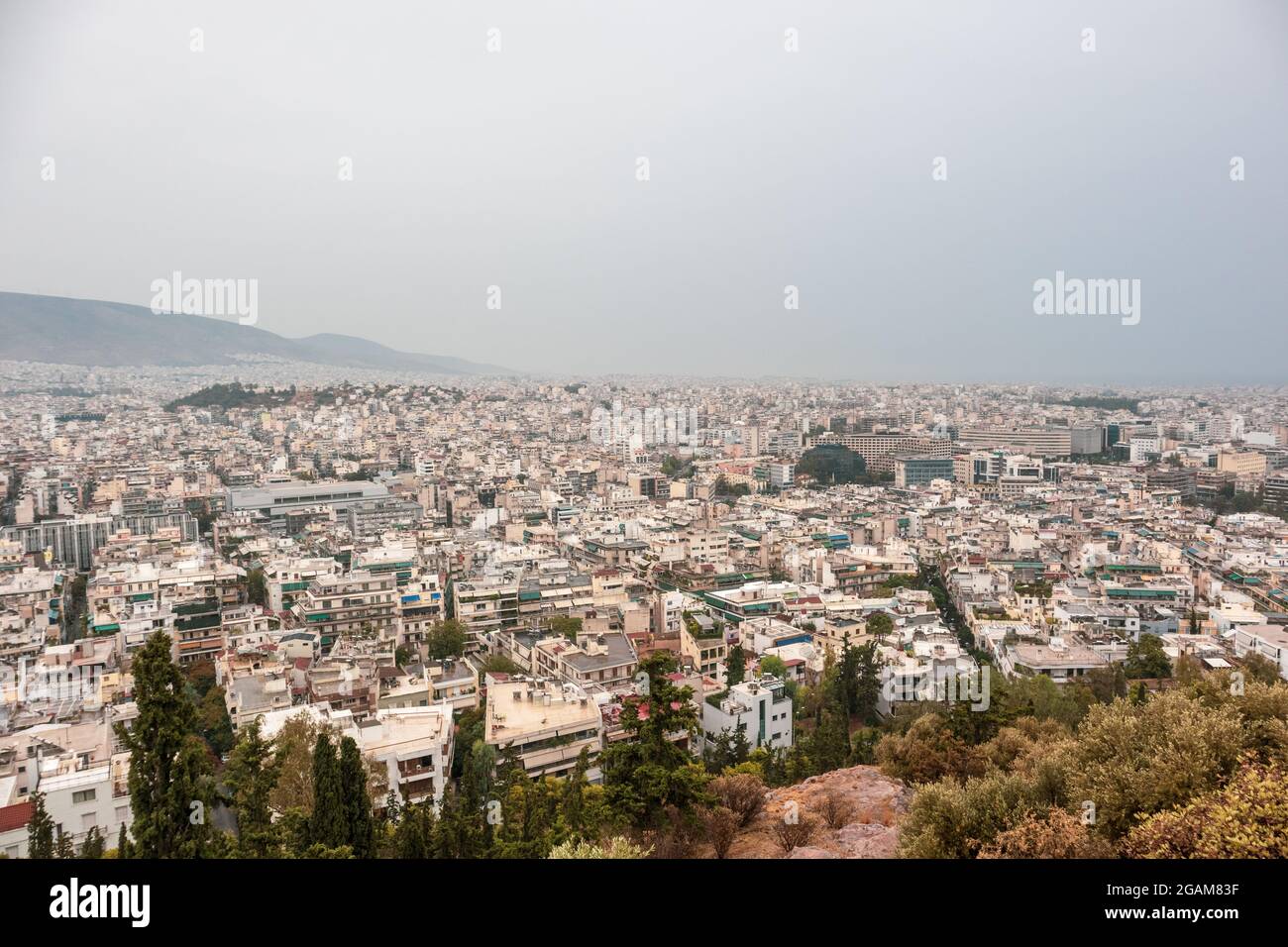 Les rues modernes du centre-ville d'Athènes sont dotées de bâtiments blancs par temps sombre. Vue sur le toit de l'Attique depuis la colline de Filopappou près de l'Acropole, Grèce Banque D'Images