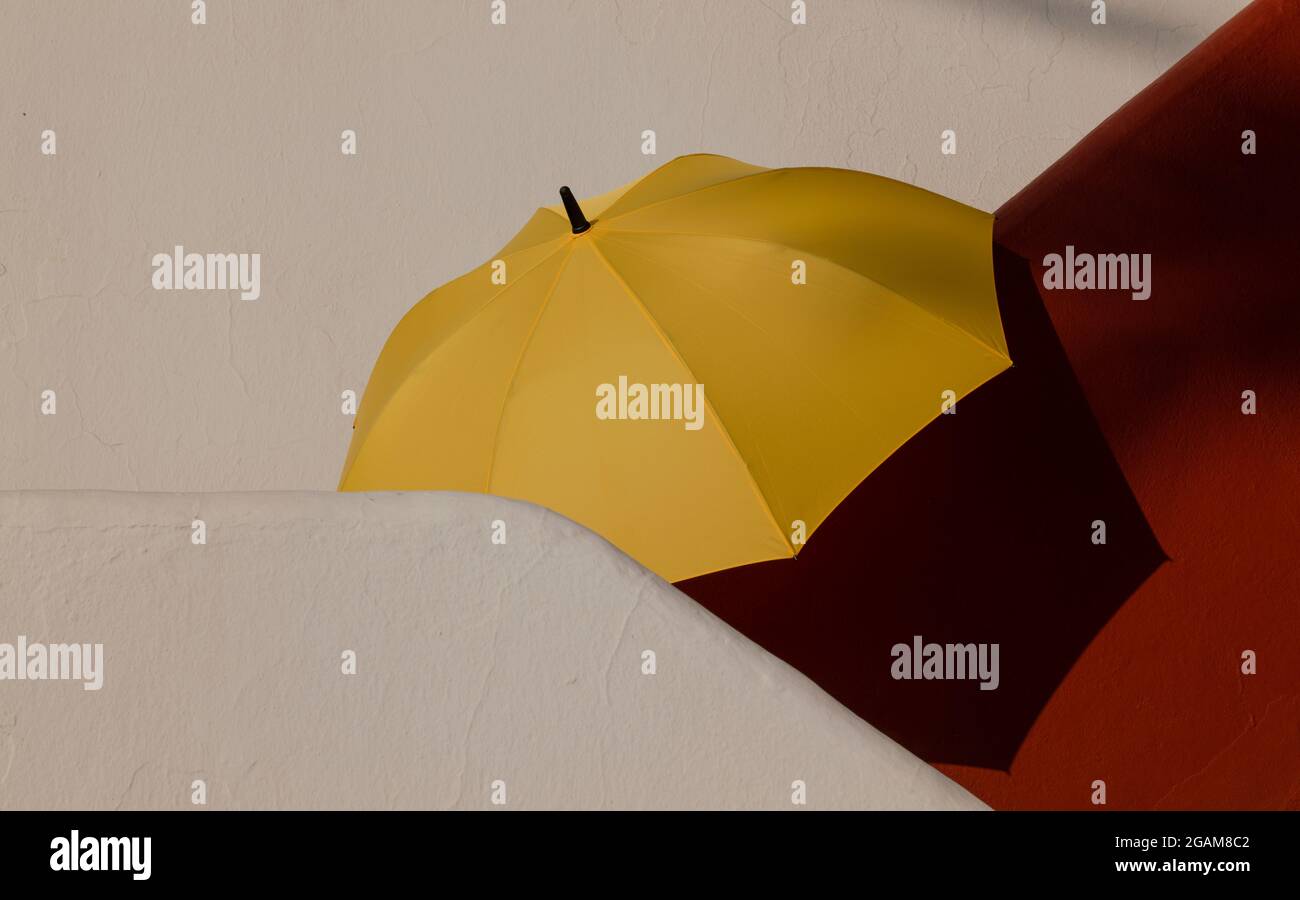 Parapluie jaune sur les escaliers blanc et rouge Banque D'Images