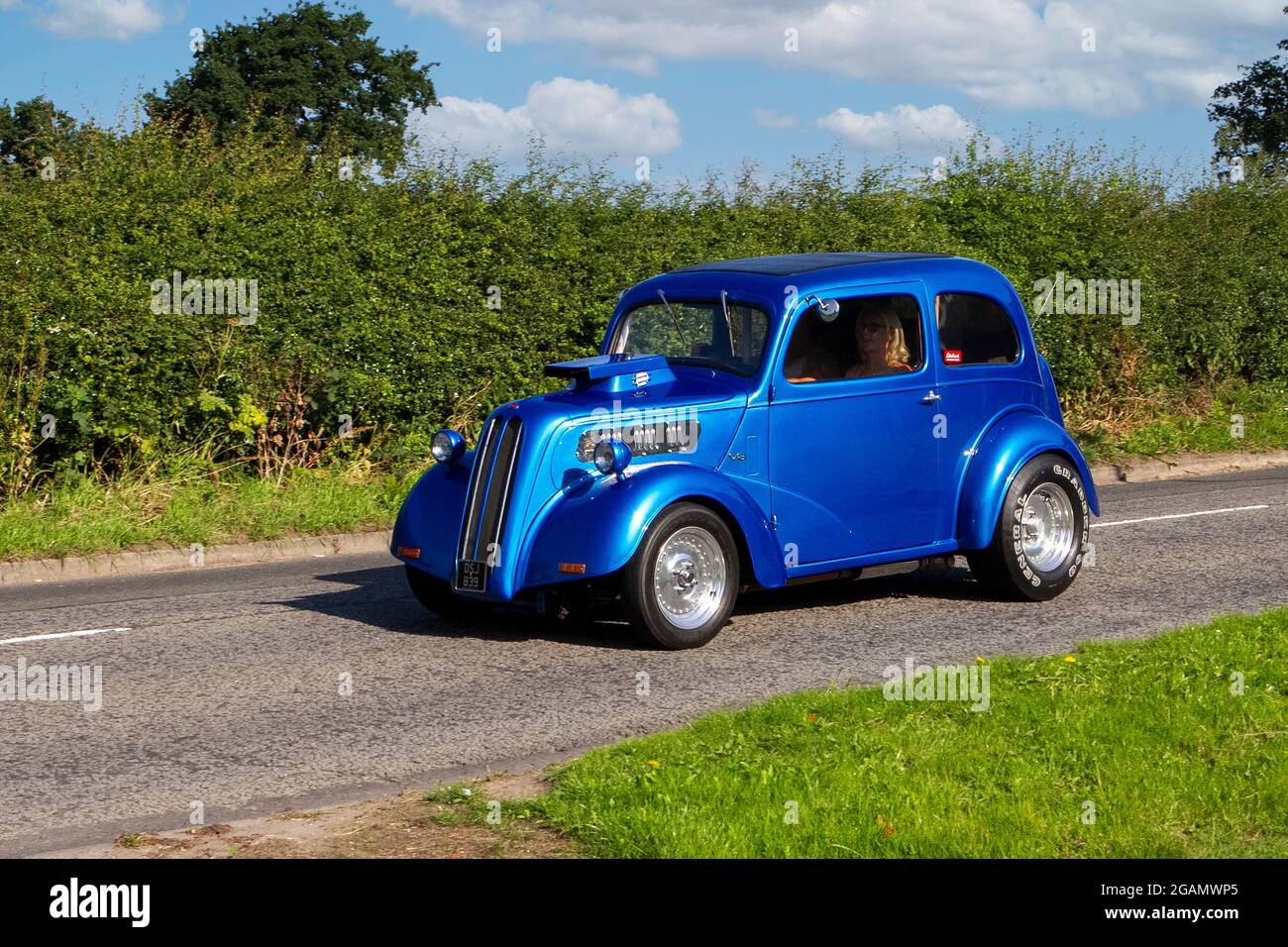 Une Ford Anglia Chrysler PT Cruiser 1960 années 60 modèle 3d drôle de voiture bleu classique vintage voiture arrivant au salon de voiture classique de Capesthorne Hall. Banque D'Images