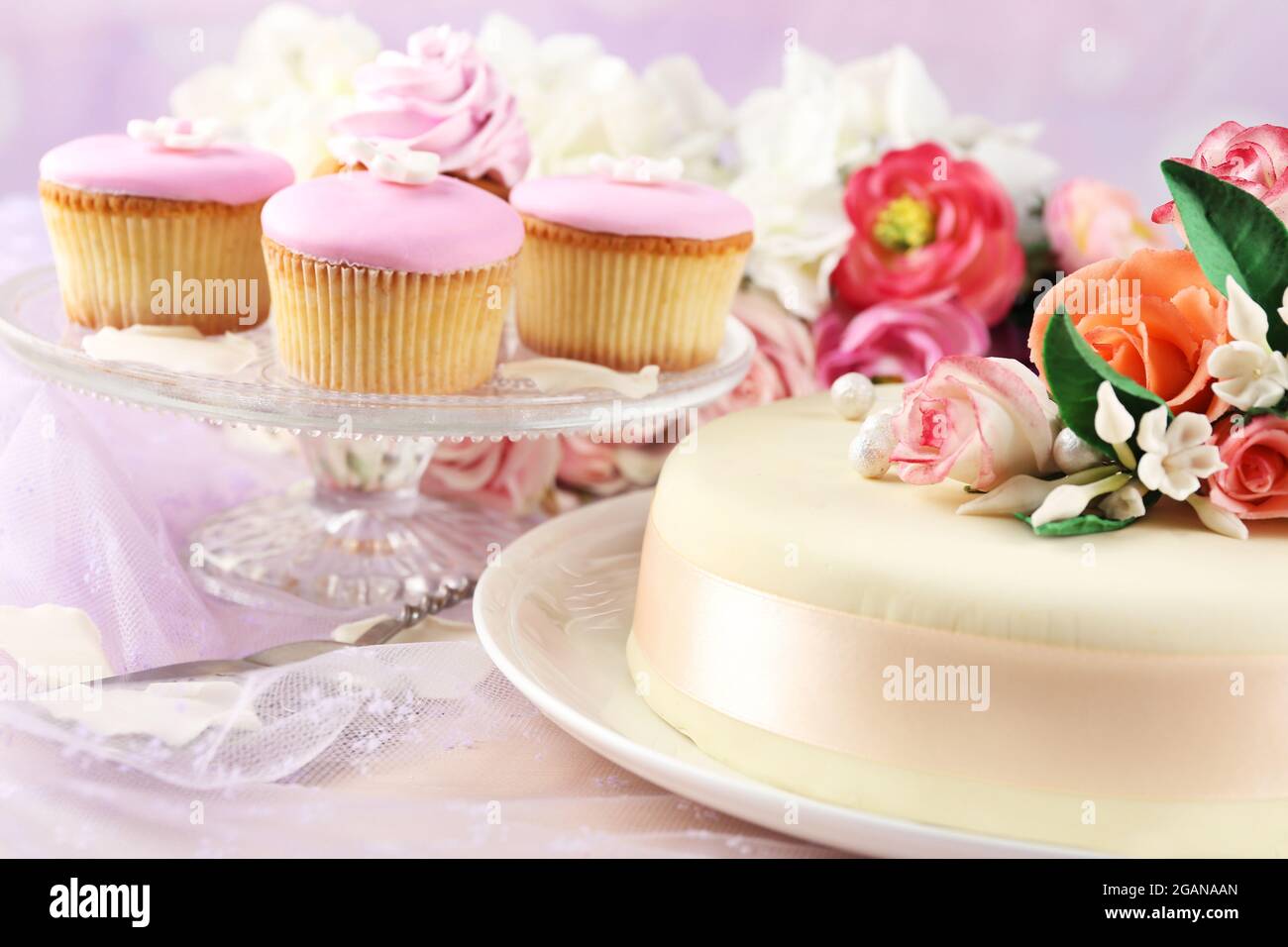 Gateau Avec Des Fleurs De Pate De Sucre Et Des Cupcakes Sur Fond Clair Photo Stock Alamy