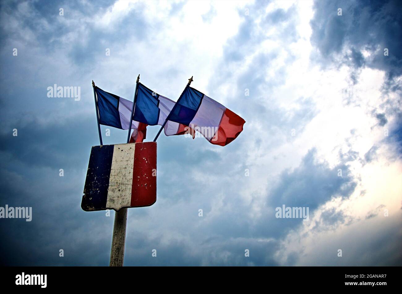 Drapeaux français agitant fièrement sur un ciel spectaculaire au crépuscule, capturant l'essence de la fierté nationale et du patrimoine Banque D'Images