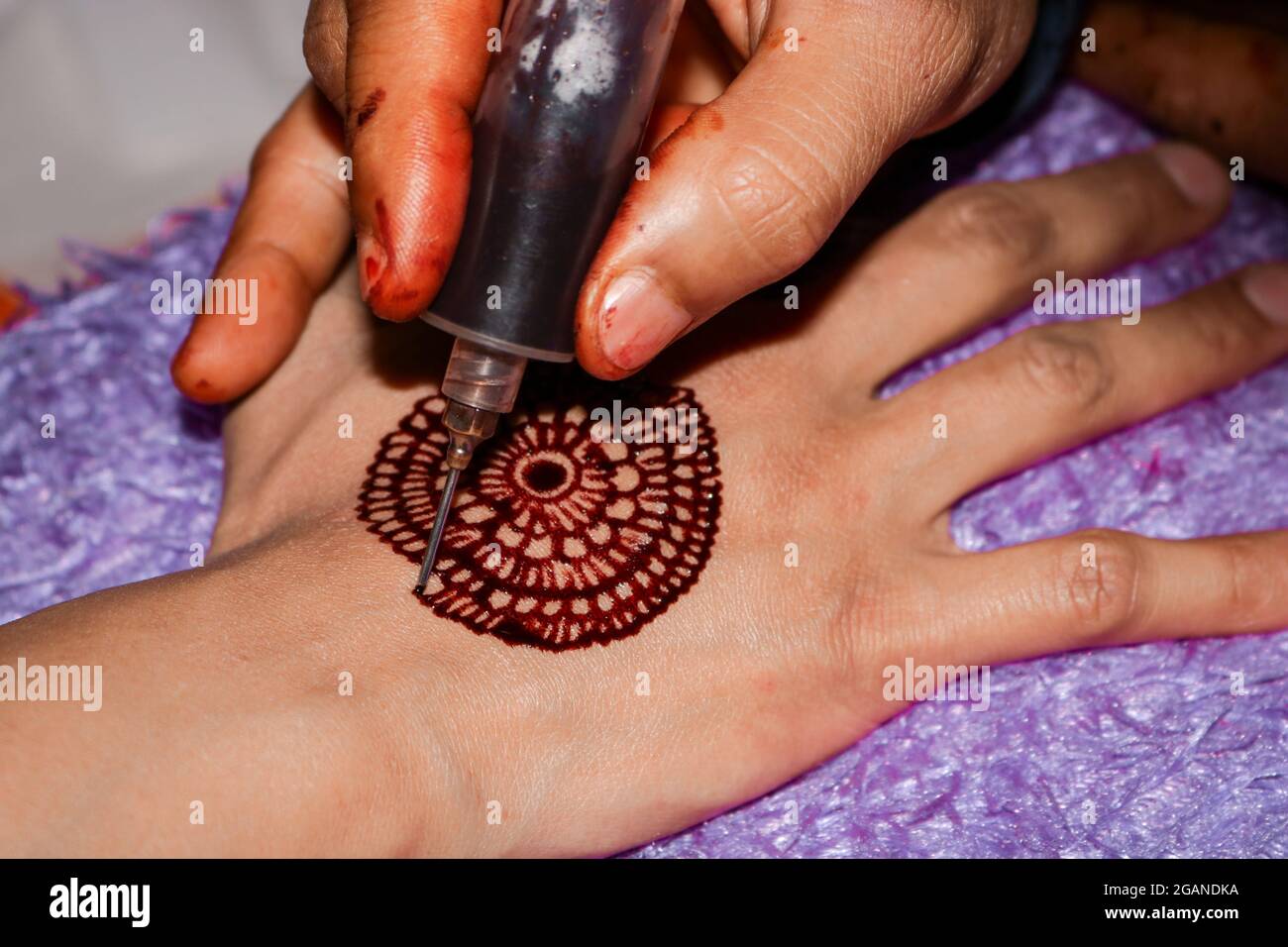 Application du henné à la main avec la seringue Banque D'Images