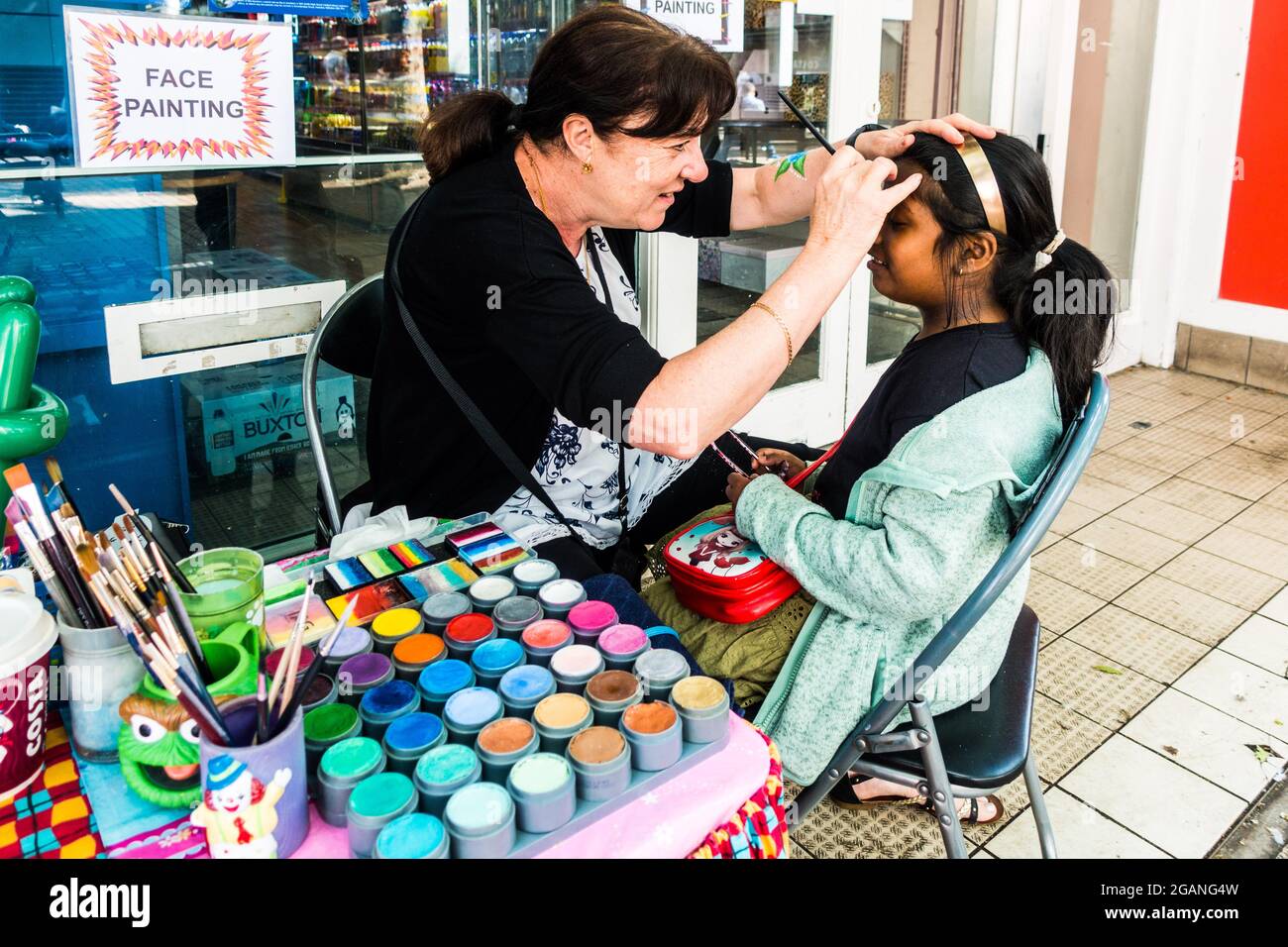 La femme âgée tire sur le visage d'une fille Banque D'Images