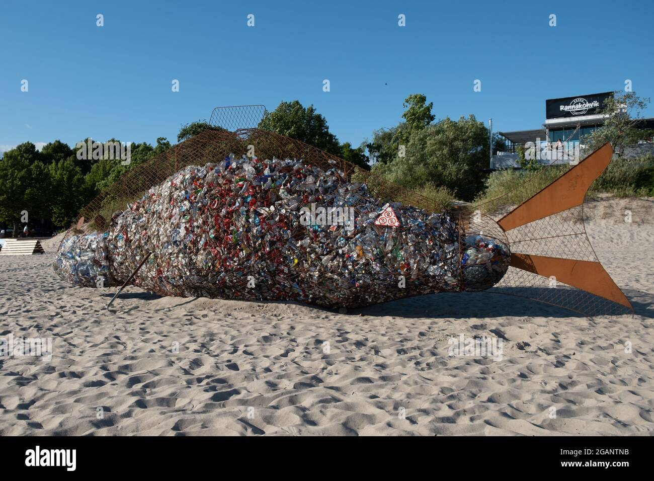 Pärnu, Estonie - 11 juillet 2021: Poubelle en fil métallique géante en forme de poisson pour la collecte des déchets de plastique sur une plage propre. Banque D'Images