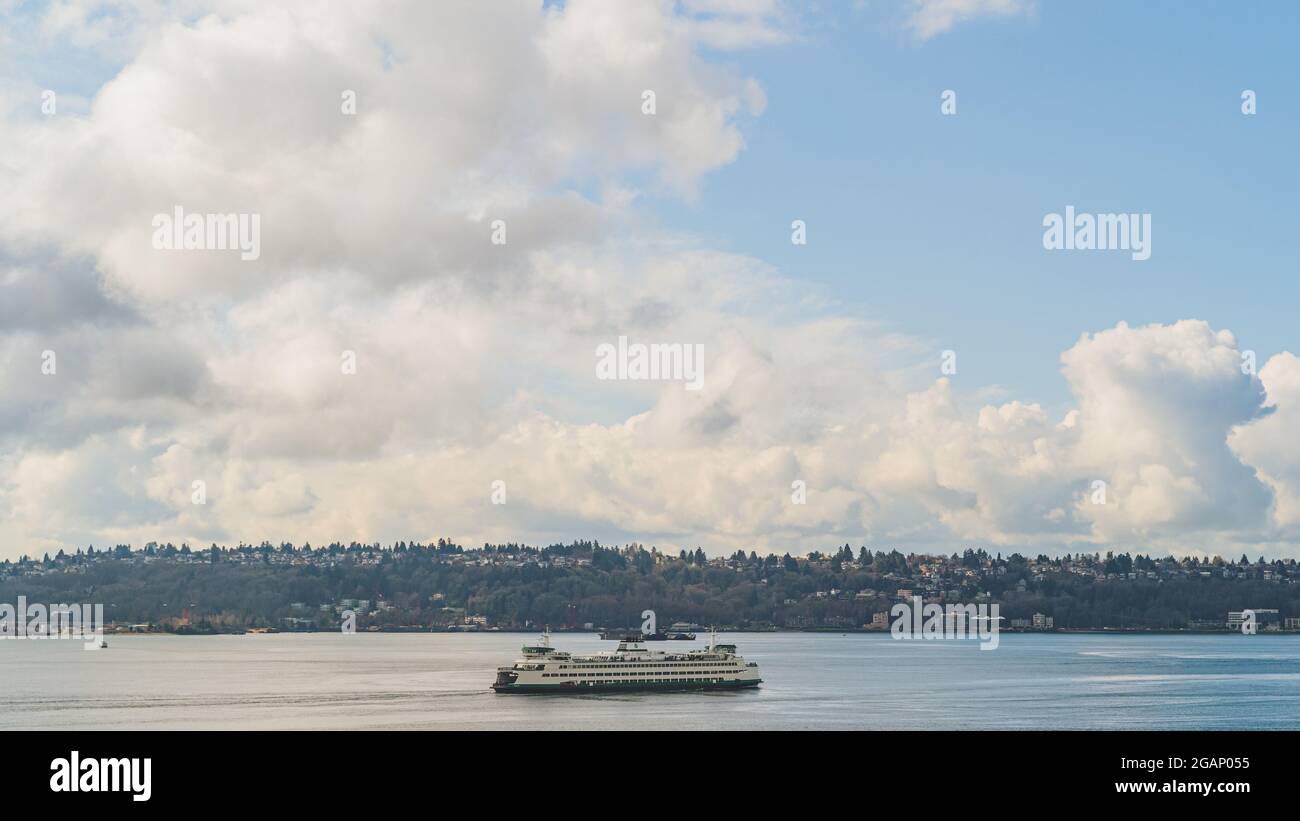 Le Washington Ferry navigue sur Elliot Bay avec l'arrière-plan West Seattle et Cloud Sky Banque D'Images