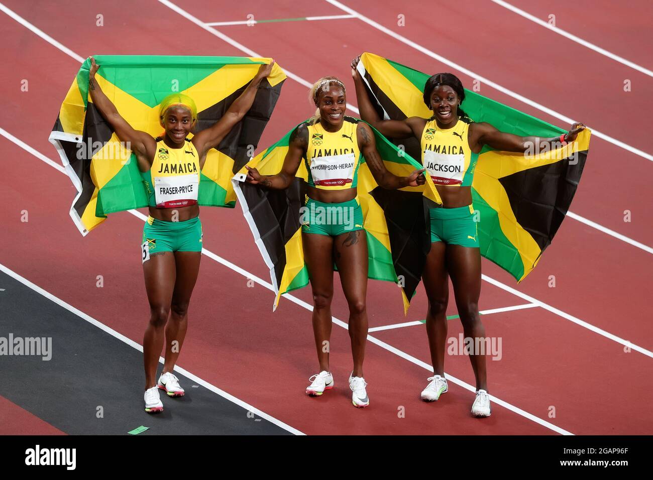 Tokyo, Japon, 31 juillet 2021. Shelly-Ann Fraser-Pryce, la finisseuse de première place Elaine Thompson Herah et la finisseuse de troisième place Shericka Jam Jackson (G-D) célèbrent avec les drapeaux jamaïcains après la finale du 100m féminin du 8 e jour des Jeux Olympiques de Tokyo 2020. Credit: Pete Dovgan/Speed Media/Alay Live News. Credit: Pete Dovgan/Speed Media/Alay Live News Banque D'Images