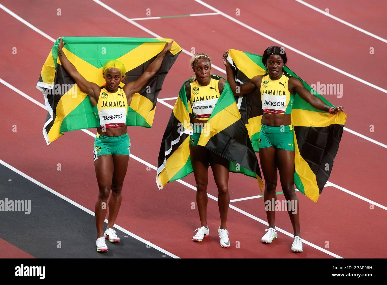 Tokyo, Japon, 31 juillet 2021. Shelly-Ann Fraser-Pryce, la finisseuse de première place Elaine Thompson Herah et la finisseuse de troisième place Shericka Jam Jackson (G-D) célèbrent avec les drapeaux jamaïcains après la finale du 100m féminin du 8 e jour des Jeux Olympiques de Tokyo 2020. Credit: Pete Dovgan/Speed Media/Alay Live News. Credit: Pete Dovgan/Speed Media/Alay Live News Banque D'Images