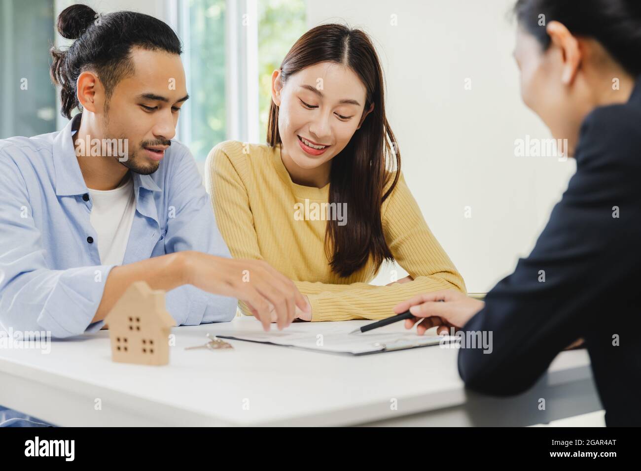 Les agents immobiliers expliquent le document aux clients avant qu'un client ne signe un contrat acheter une maison, acheter ou vendre un concept immobilier Banque D'Images