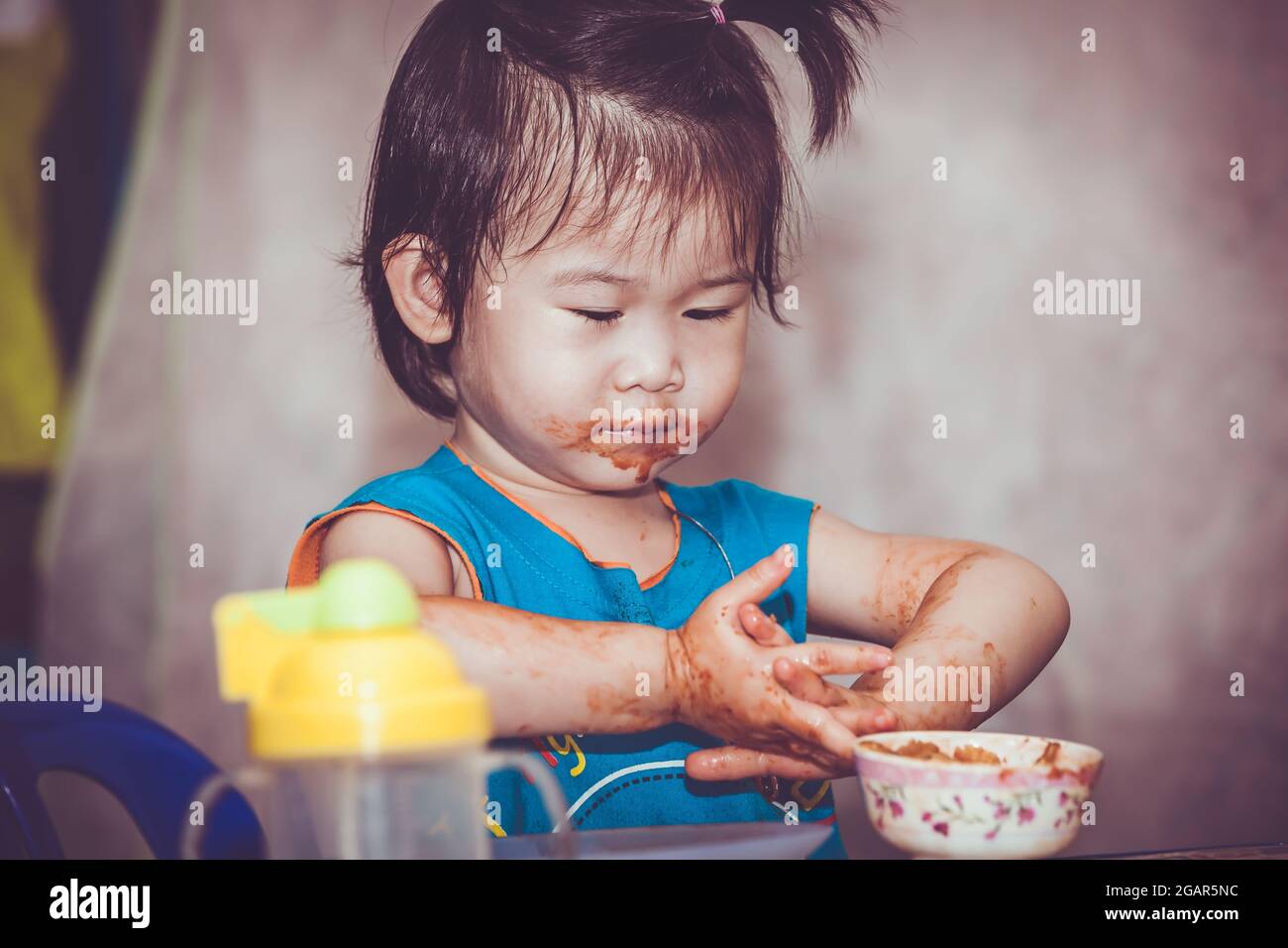 Portrait d'un enfant asiatique aiment manger. Sa main et sa bouche se  tachèrent de ketchup. Charmante fille jouant avec la nourriture et  apprenant à manger. Face sale o Photo Stock - Alamy