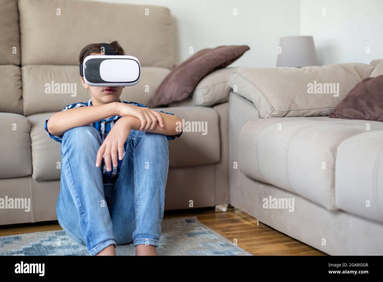 Un adolescent de race blanche passe du temps dans la réalité virtuelle à la maison. Banque D'Images