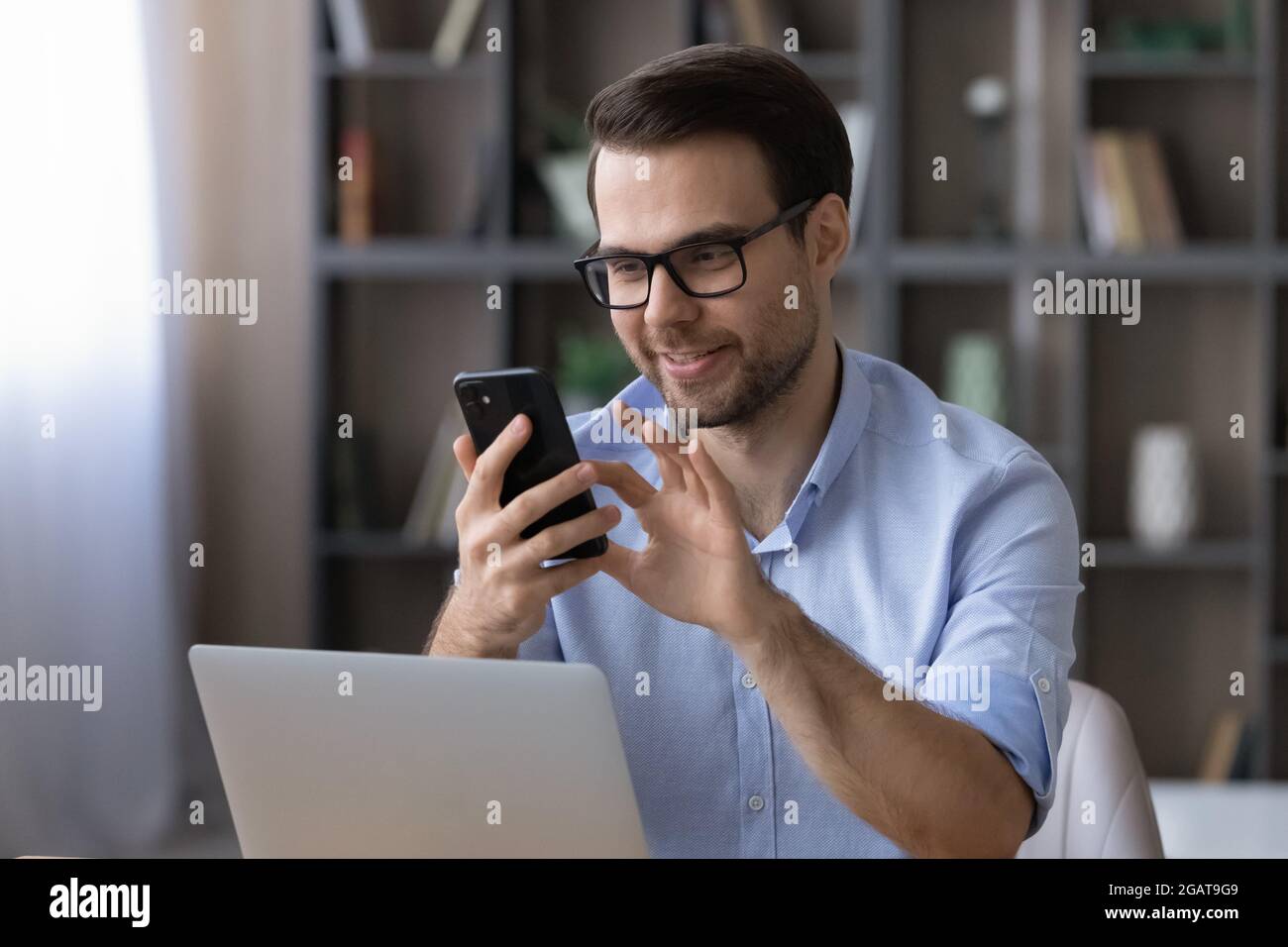 Un agent d'assurance jeune homme passe un appel téléphonique professionnel depuis son lieu de travail Banque D'Images