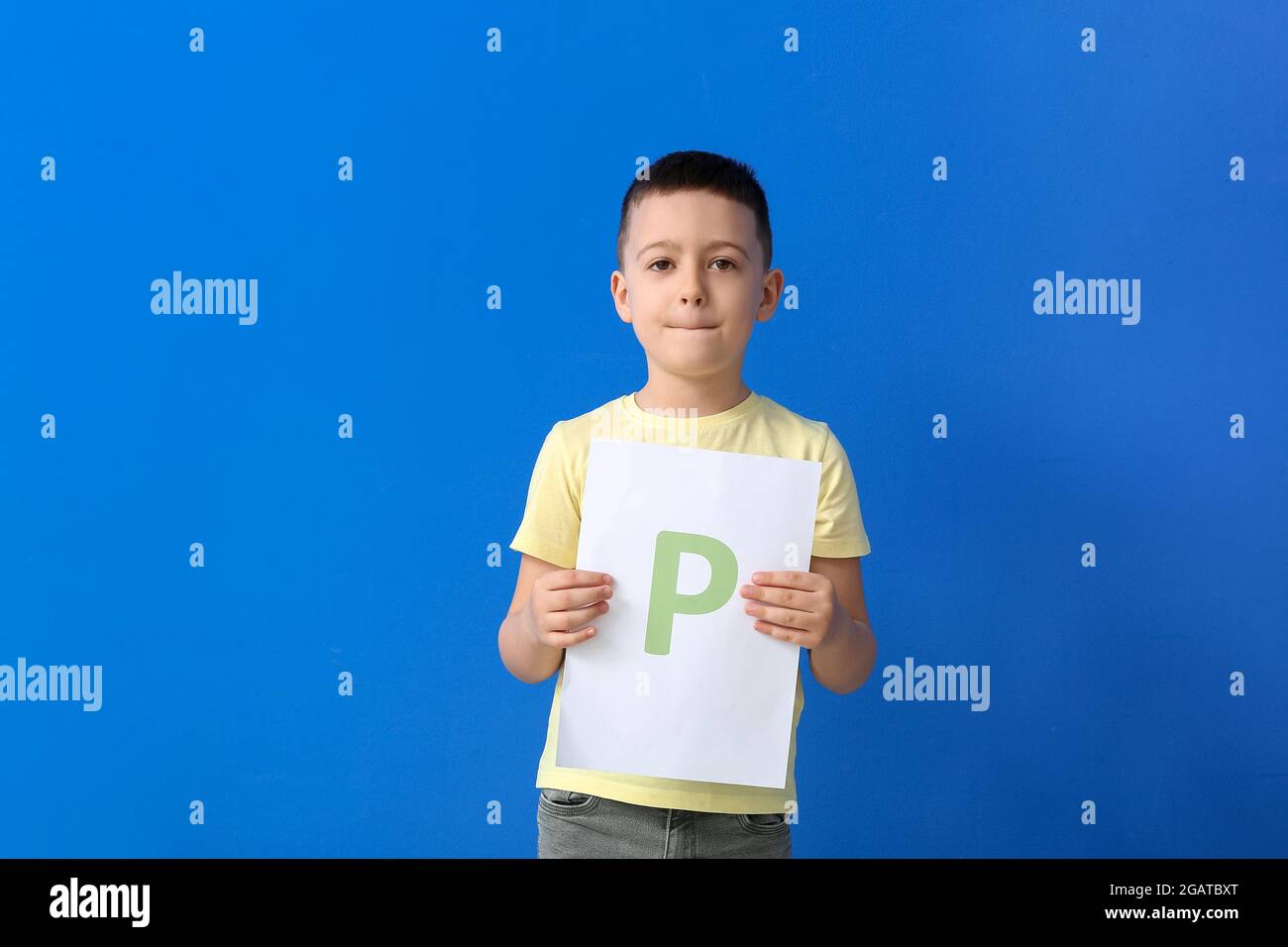 Petit garçon tenant une feuille de papier avec la lettre P sur fond de  couleur Photo Stock - Alamy