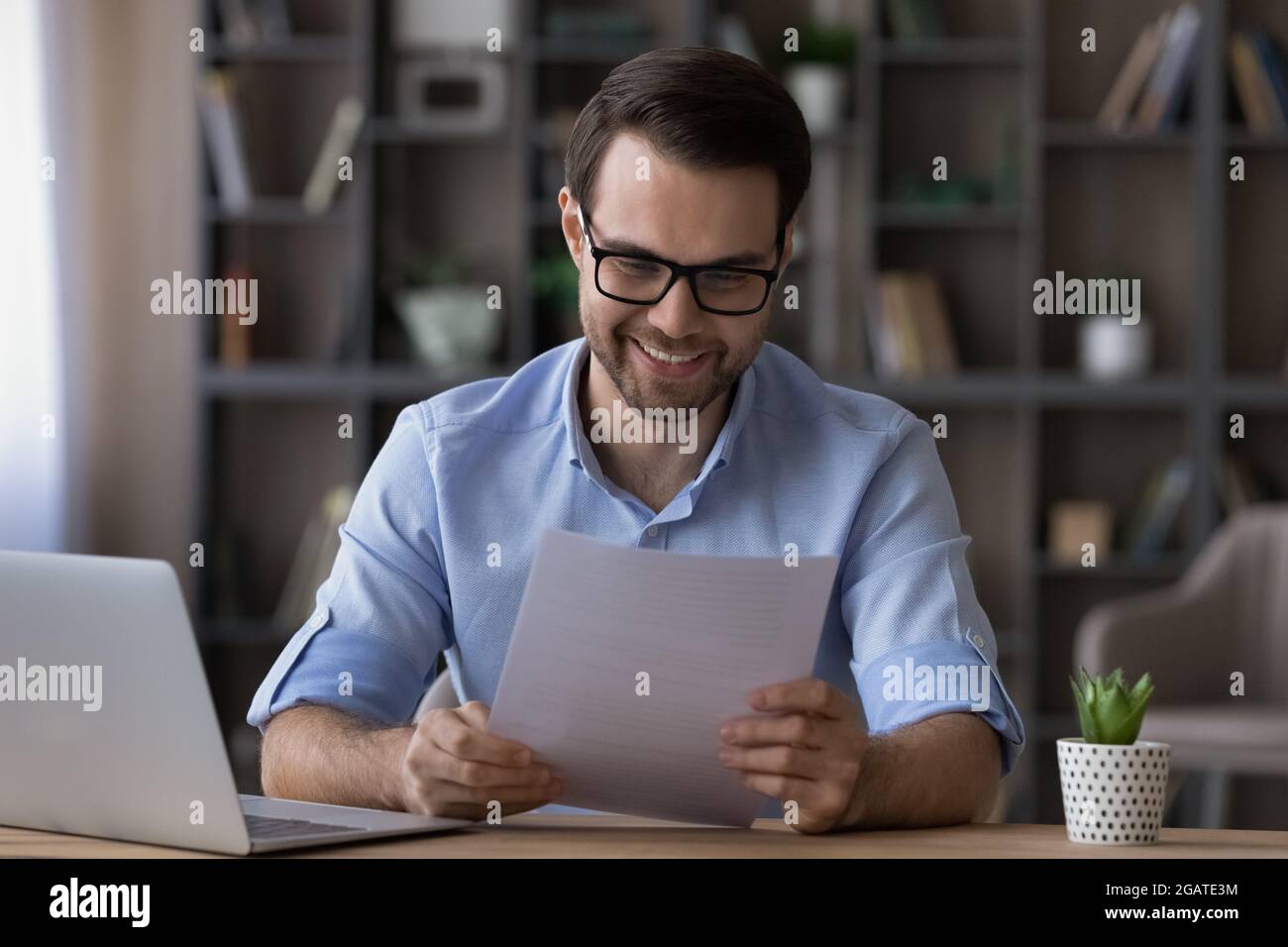 Un jeune homme d'affaires heureux aime lire les bonnes nouvelles dans une lettre papier Banque D'Images