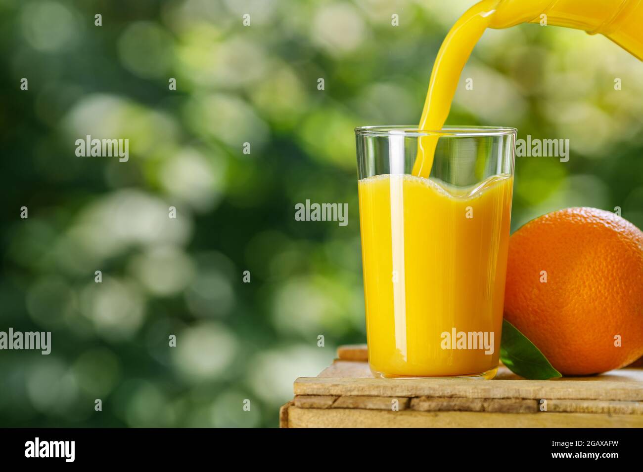 jus d'orange frais versé dans le verre à l'extérieur Banque D'Images