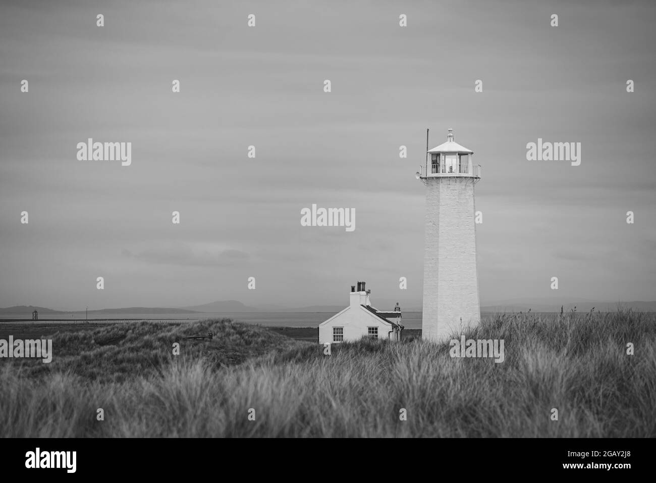 Magnifique paysage de prairie de dunes sur Walney Island avec le phare et le cottage en noir et blanc Banque D'Images