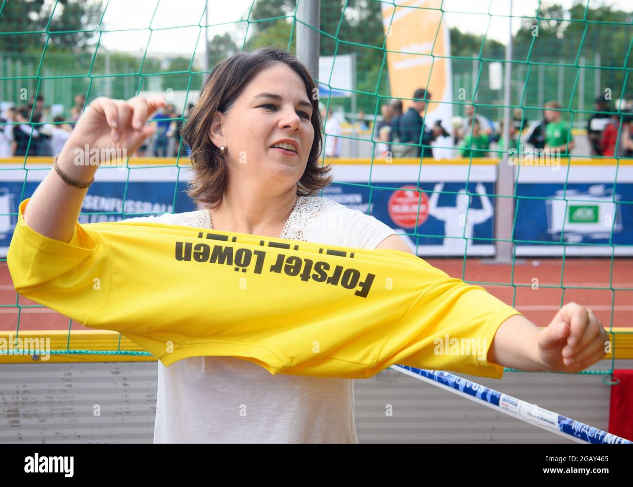 Potsdam, Allemagne. 1er août 2021. Annalena Baerbock, candidate à la chancellerie et première candidate de Bündnis 90/Die Grünen, reçoit un T-shirt jaune avec le numéro dix comme cadeau du 'Forster Löwen' pendant le tournoi de football de la jeunesse 're:start'. Le tournoi 're:start Street Soccer Championship' est organisé par la Brandenburg Sports Youth. L'objectif est d'amener les enfants et les jeunes à se déplacer à nouveau après la pandémie et d'inspirer les enfants d'un large éventail de familles à adopter le sport de club. Credit: Soeren Stache/dpa-Zentralbild/dpa/Alay Live News Banque D'Images