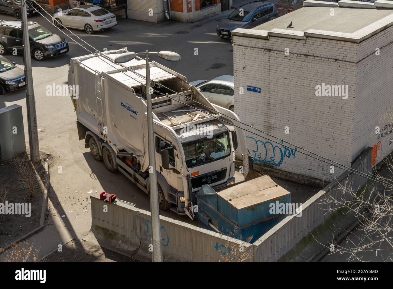 Heil Environmental MAN TGS camion à chargement frontal automatisé cueillant un grand conteneur à ordures en métal, vue à angle élevé, Saint-Pétersbourg, Russie Banque D'Images