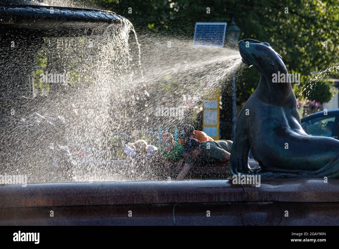 Enfants derrière des jets d'eau de la sculpture Havis Amanda à Helsinki, en Finlande Banque D'Images