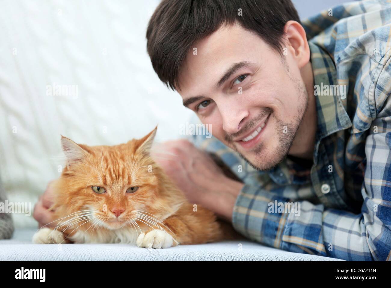 Jeune Homme Avec Chat Moelleux Allonge Sur Un Canape Photo Stock Alamy