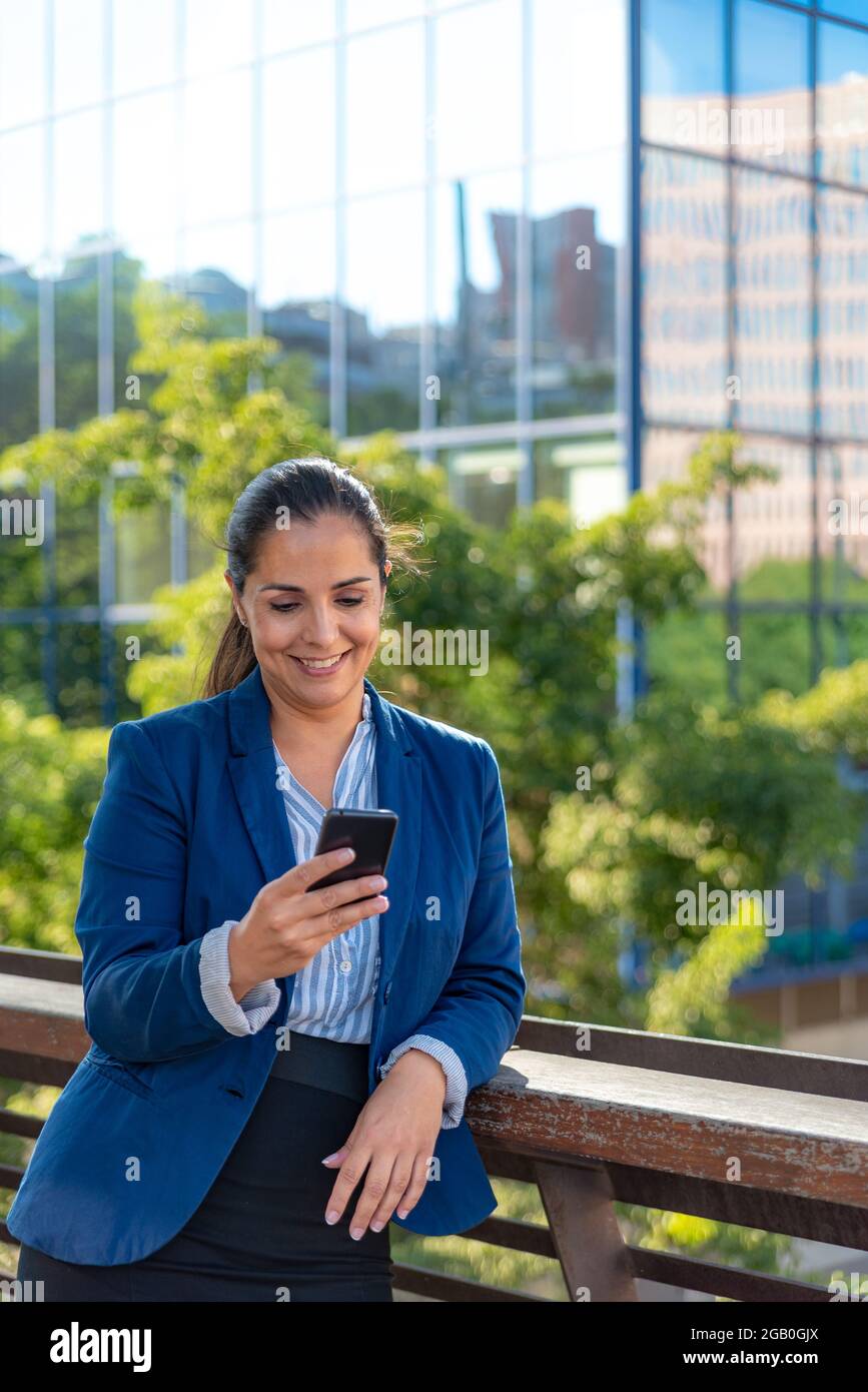 Femme d'affaires caucasienne avec téléphone mobile dans la ville Banque D'Images