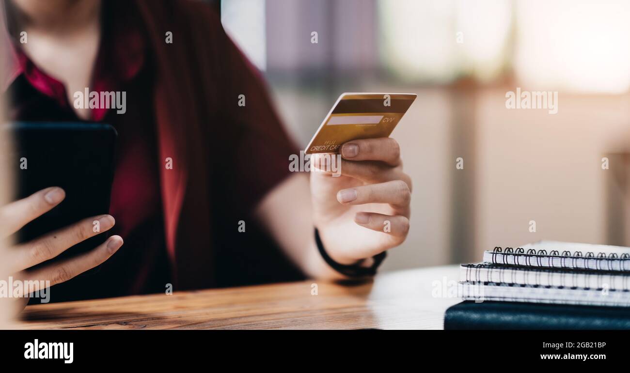 Femme utilisant une carte de crédit et un téléphone mobile pour les achats en ligne et le paiement par Internet via l'application bancaire mobile Banque D'Images