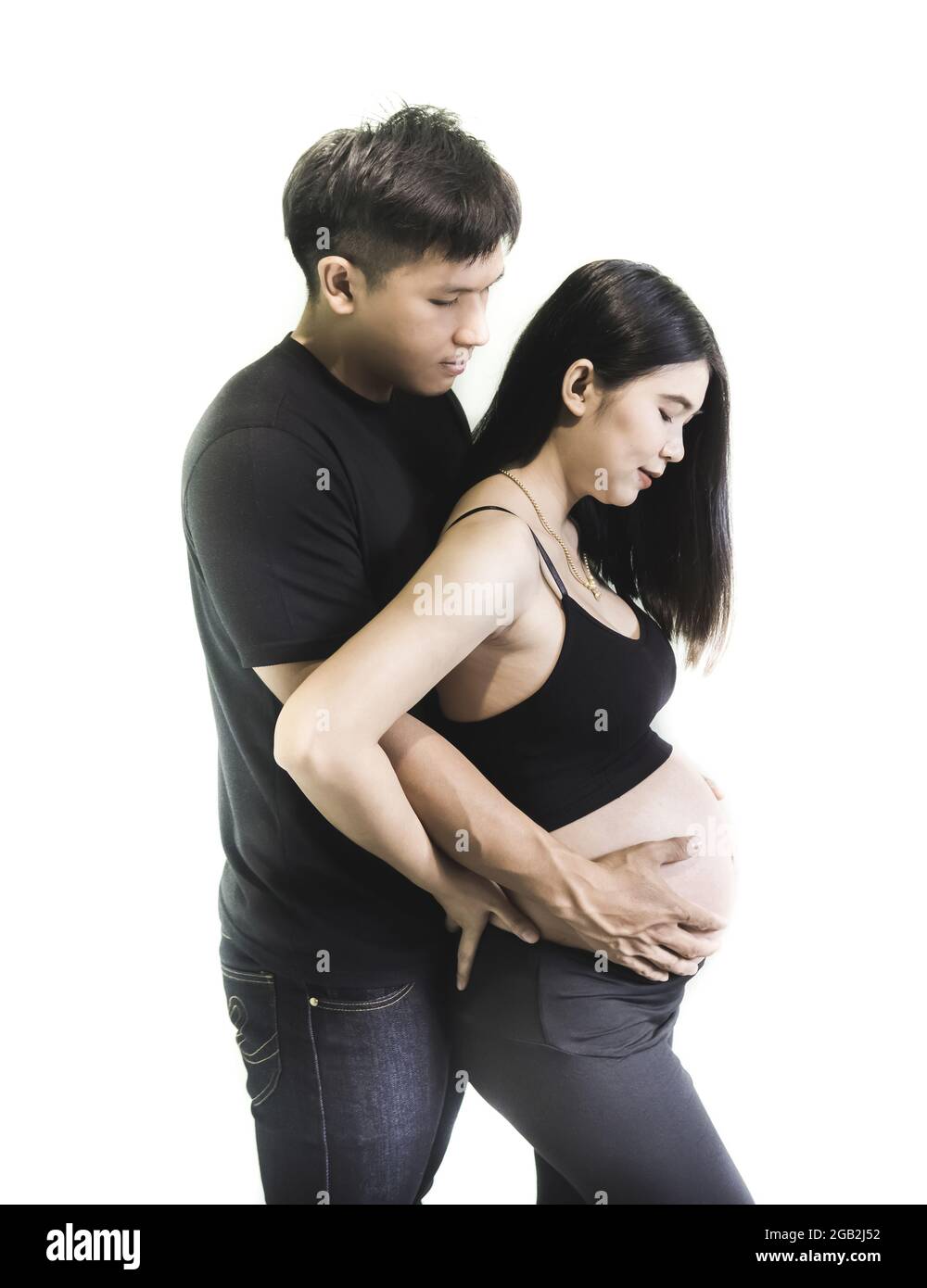 Jeune couple enceinte asiatique montrant l'amour et les soins sur fond blanc. Banque D'Images