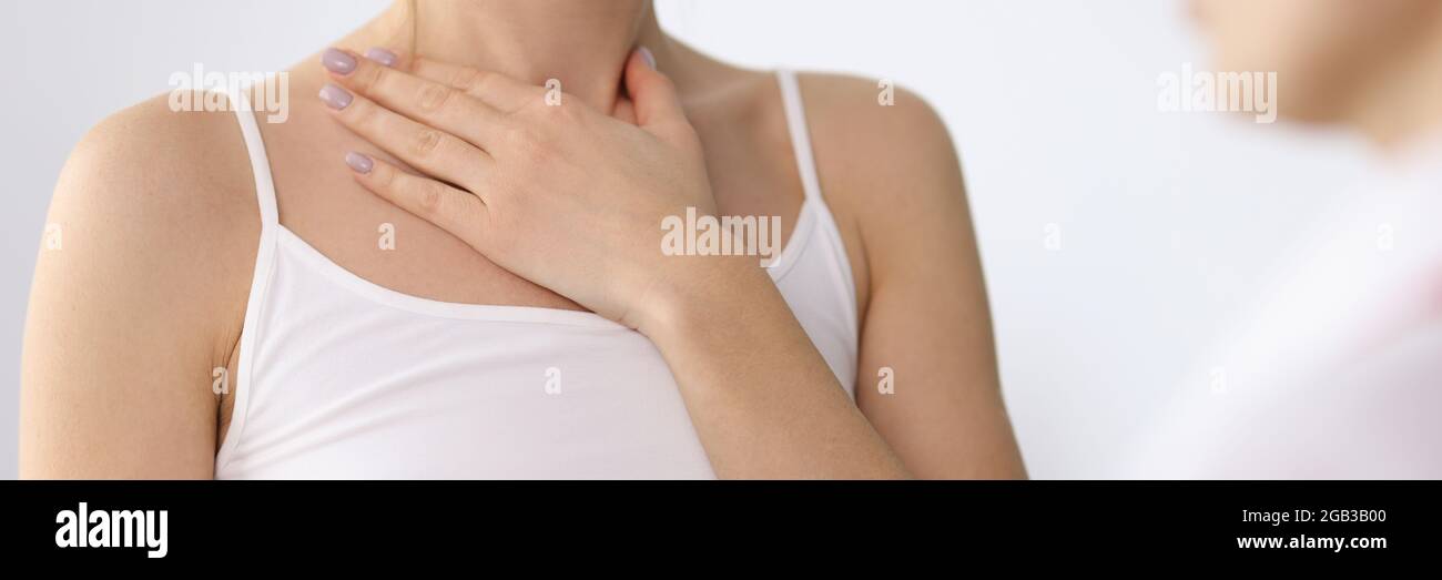 Main de femme montrant une plaie au cou lors d'un rendez-vous avec un médecin en gros plan Banque D'Images