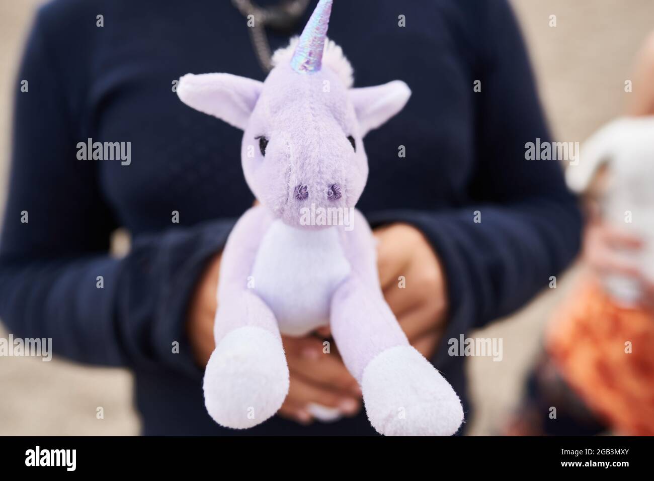 gros plan d'un enfant tenant un ours en peluche licorne Banque D'Images